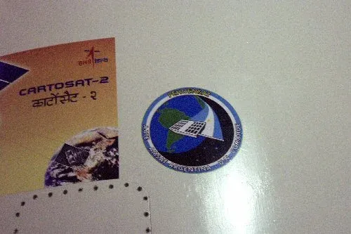 Emblema del Pehuensat-1 junto al del satélite Cartosat-2
